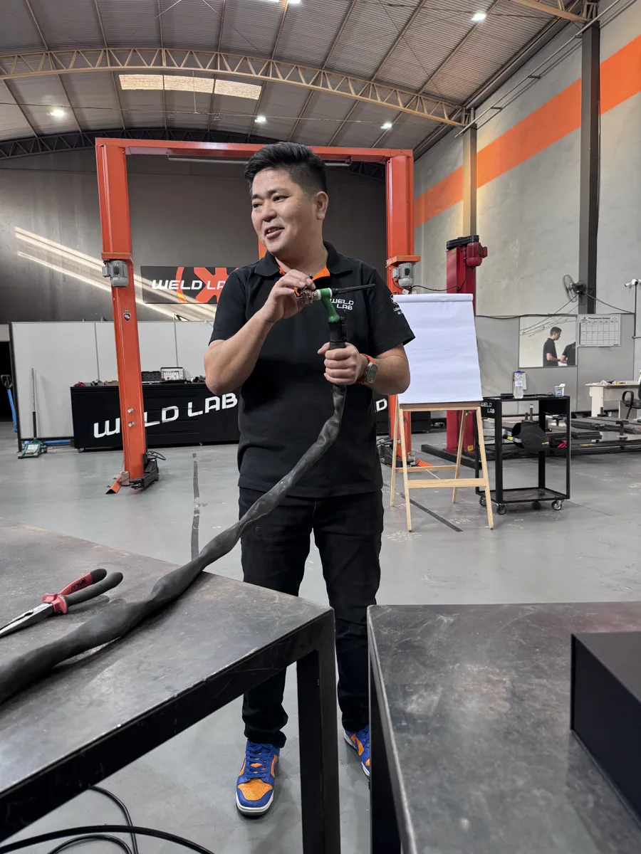 Massaru Oyama mostrando a tocha TIG durante treinamento na Weldlab